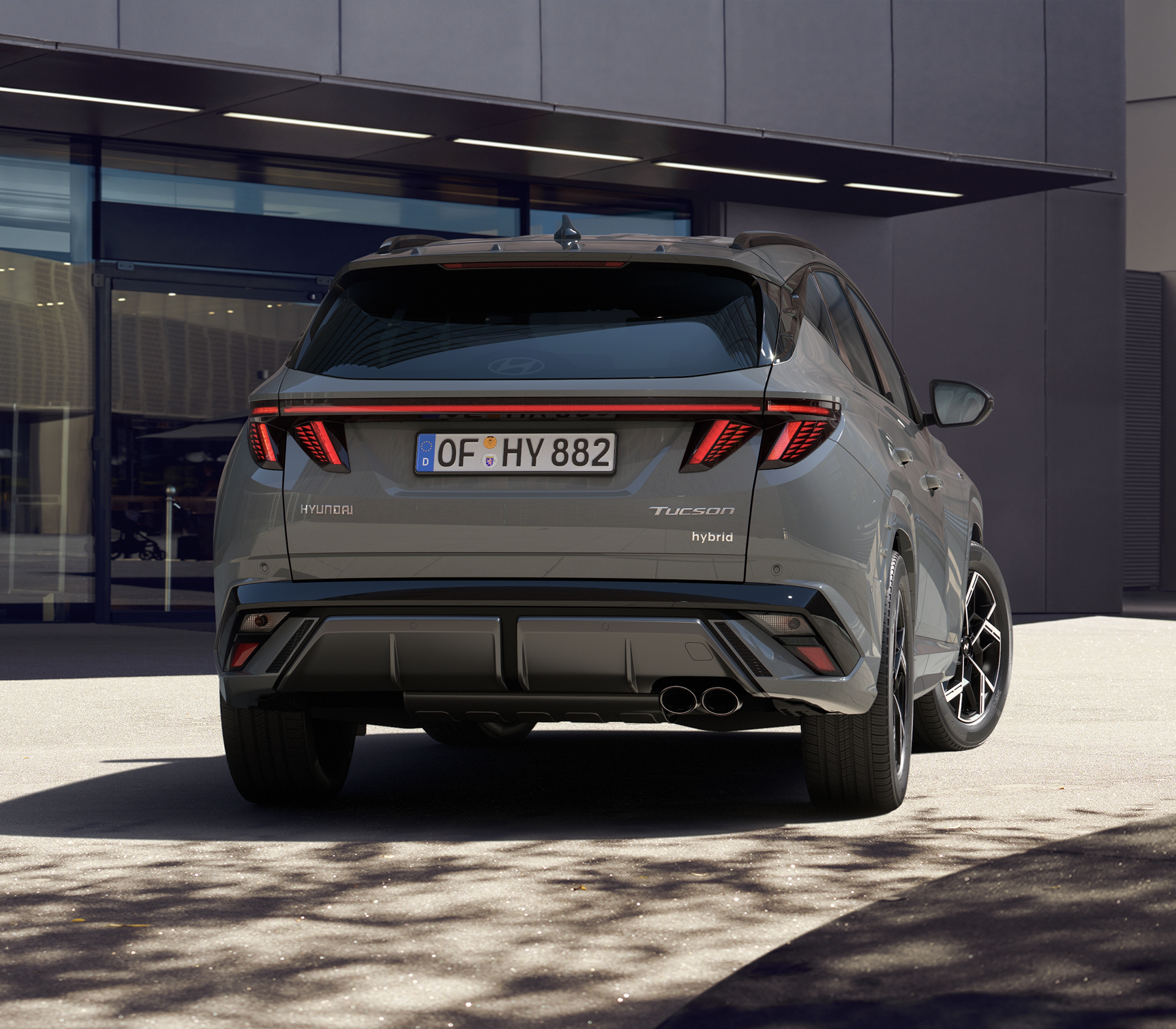 Hyundai TUCSON in grau Heckansicht mit Schatten vom Baum