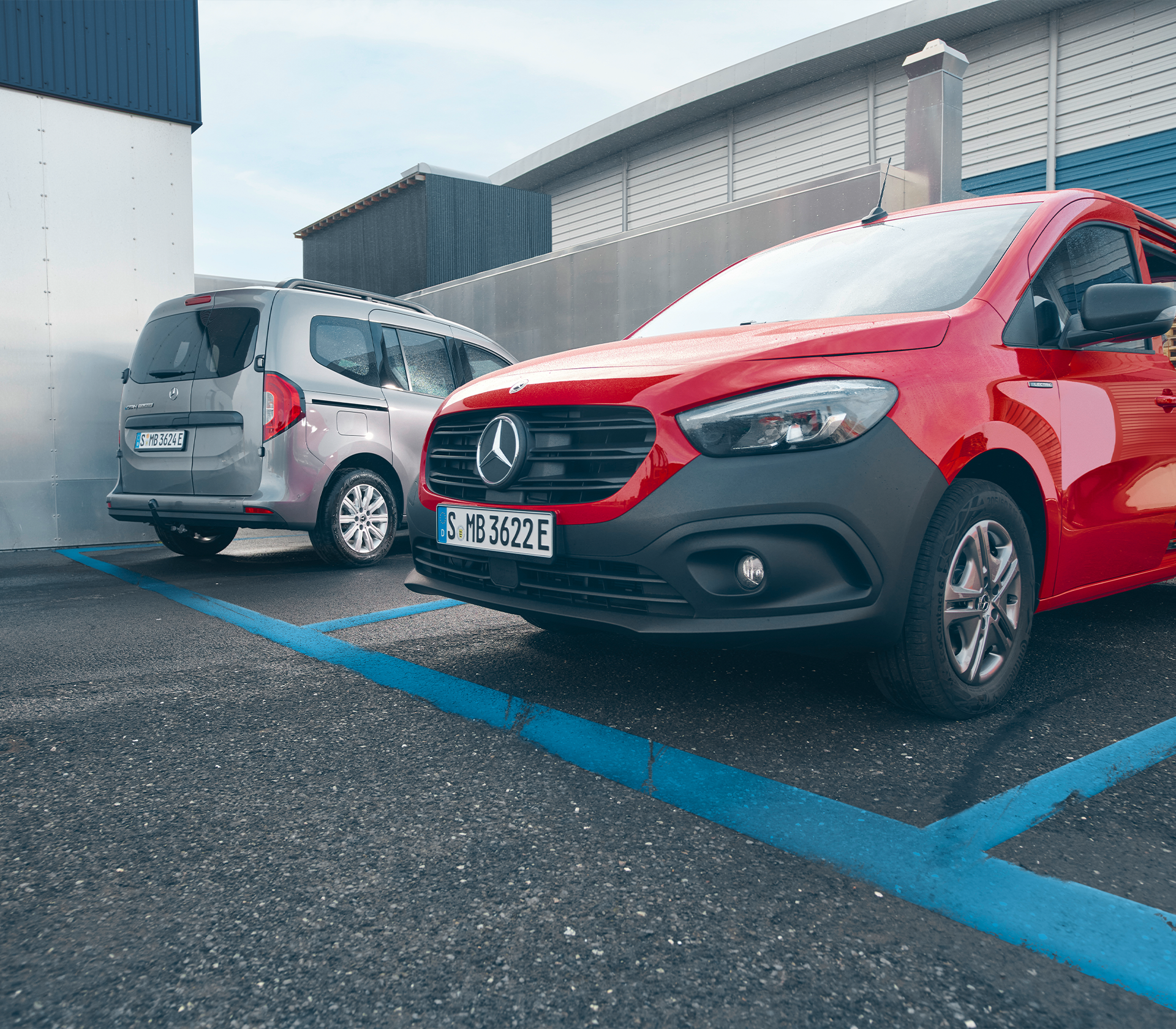 Zwei Mercedes-Benz eCitan in Rot und Grau nebeneinander geparkt – ein markanter Kontrast zwischen Kastenwagen- und Tourer-Variante.