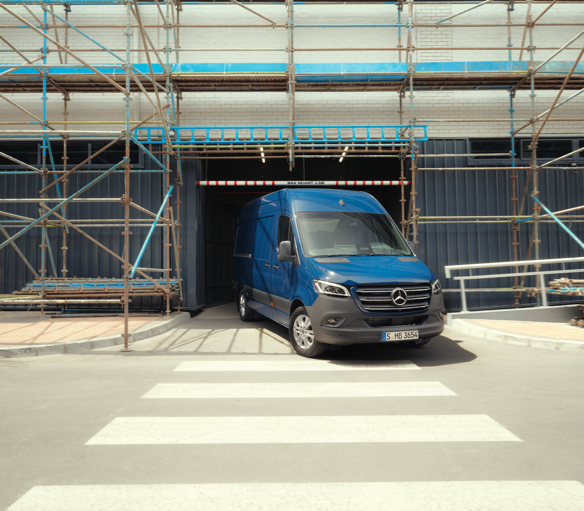 Mercedes-Benz Sprinter in blau vor einer Baustelle mit einem Gerüst