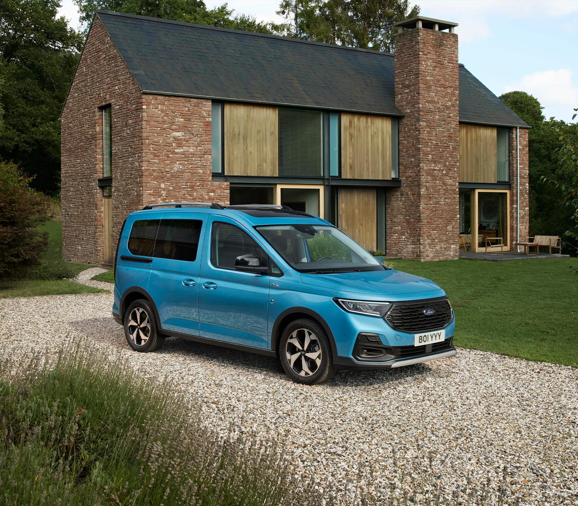 blauer Ford Tourneo-Connect steht in der Einfahrt vor einem Haus