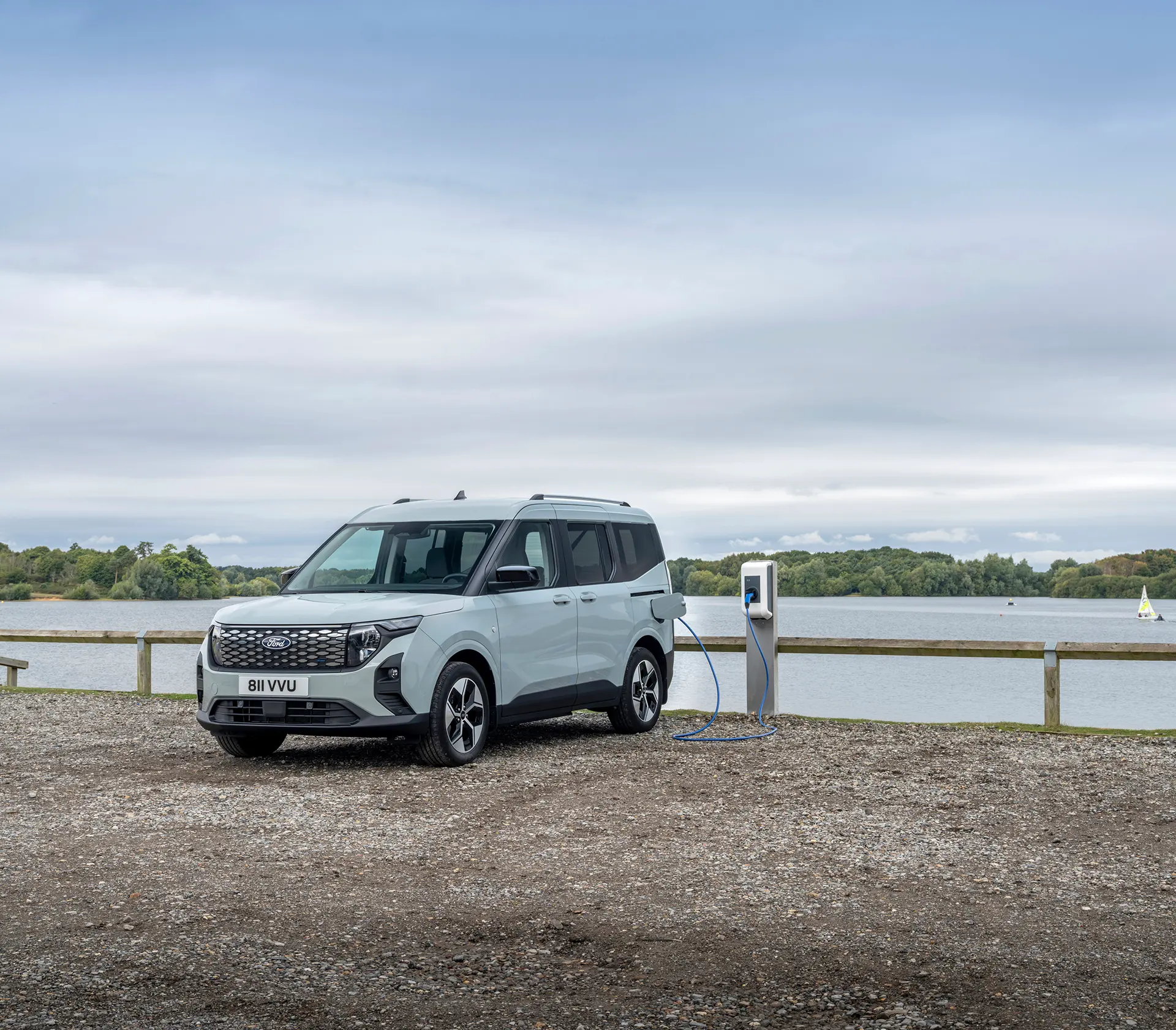 E-Tourneo Courier läd an der Ladesäule mit See im Hintergrund