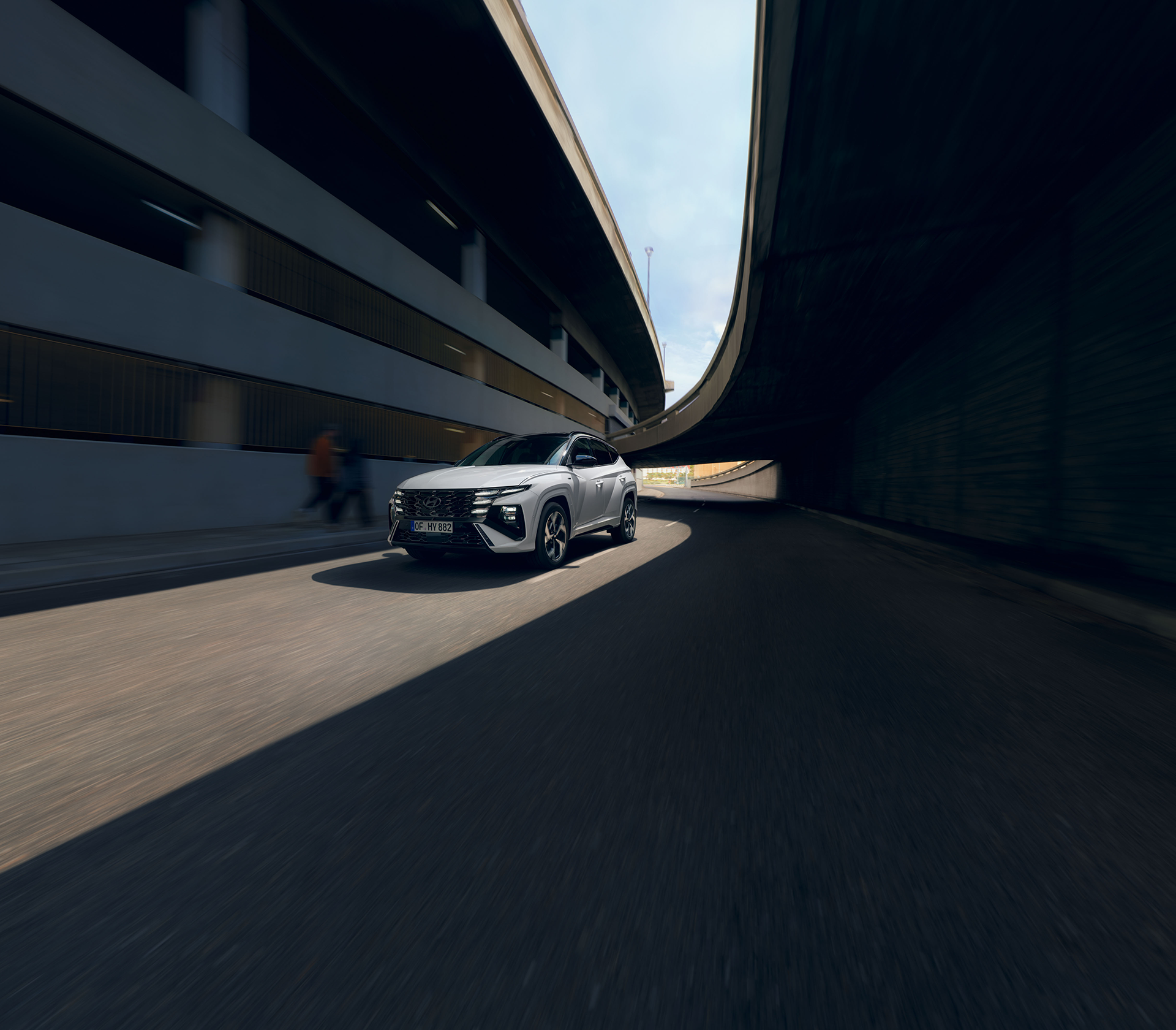 Hyundai TUCSON fährt zwischen einem Parkhaus mit Schattenspiel