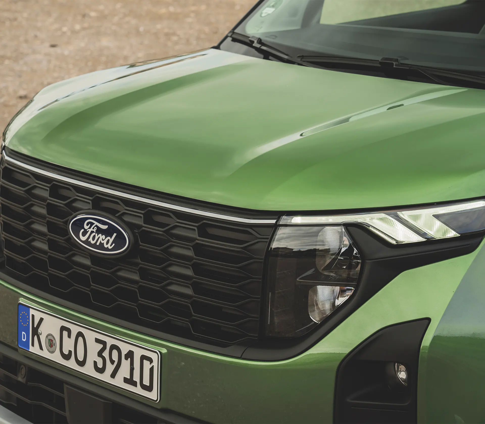 der Kühlergrill eines grünen Tourneo Courier