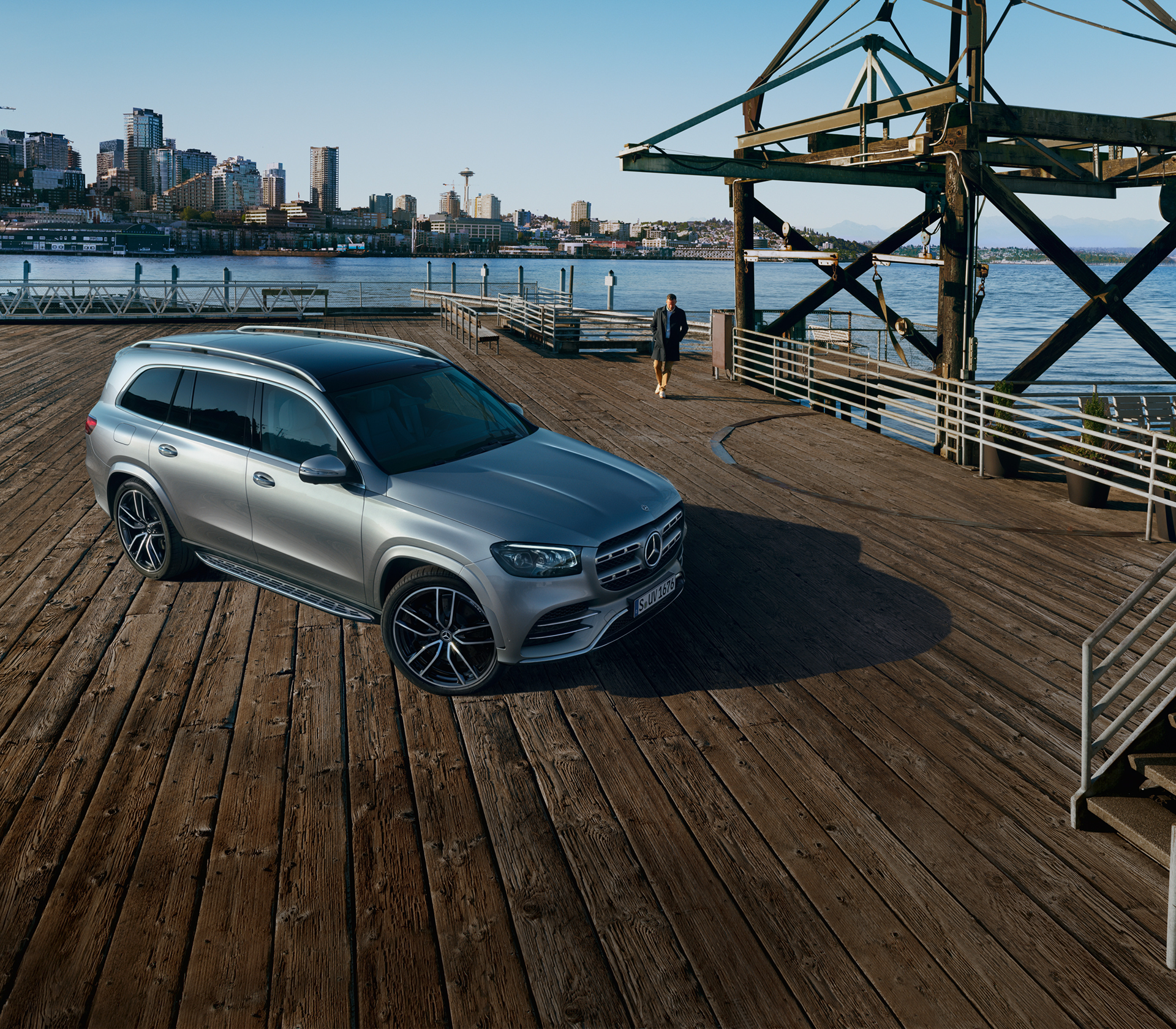 Mercedes-Benz Front- und Seitenansicht steht auf einer Plattform die von Wasser umgeben ist und im Hintergrund sieht man eine Großstadt