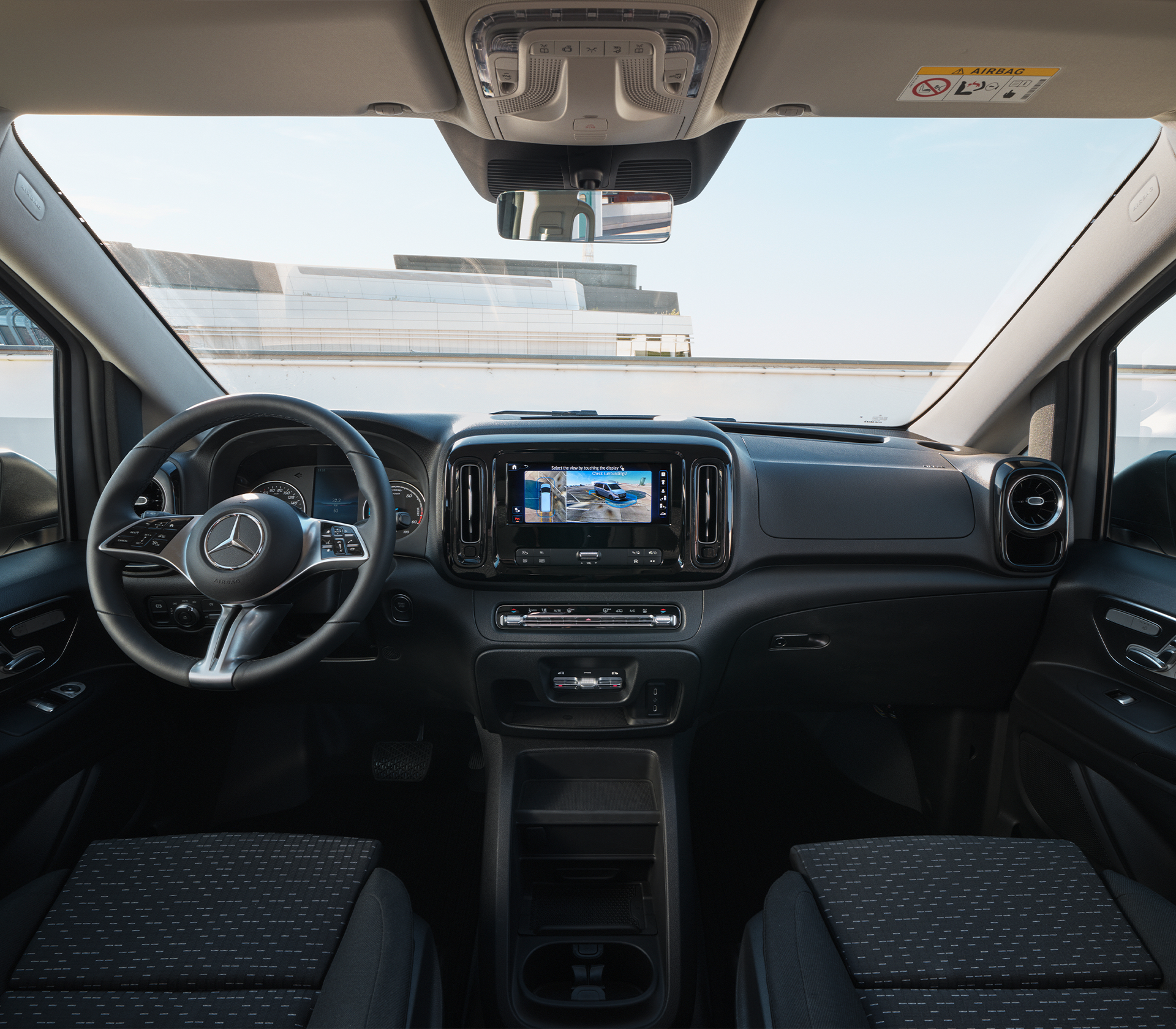 „Innenraumansicht des Mercedes-Benz e-Vito mit Fokus auf das moderne Cockpit, Multifunktionslenkrad und zentrales Touchdisplay.