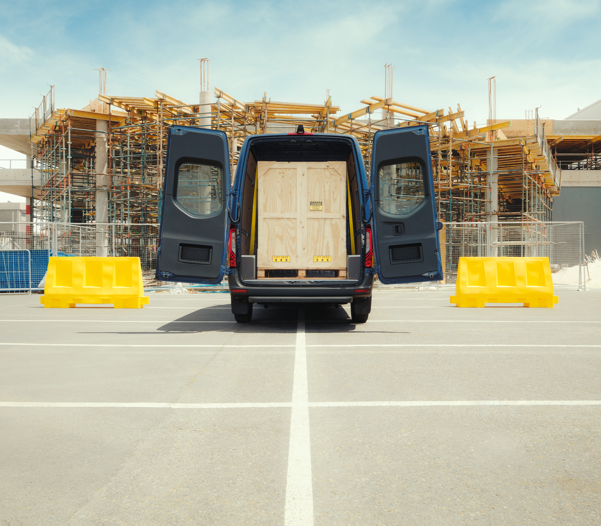 Mercedes-Benz Sprinter vor einer Baustelle mit offenen Ladetüren und ladung innen
