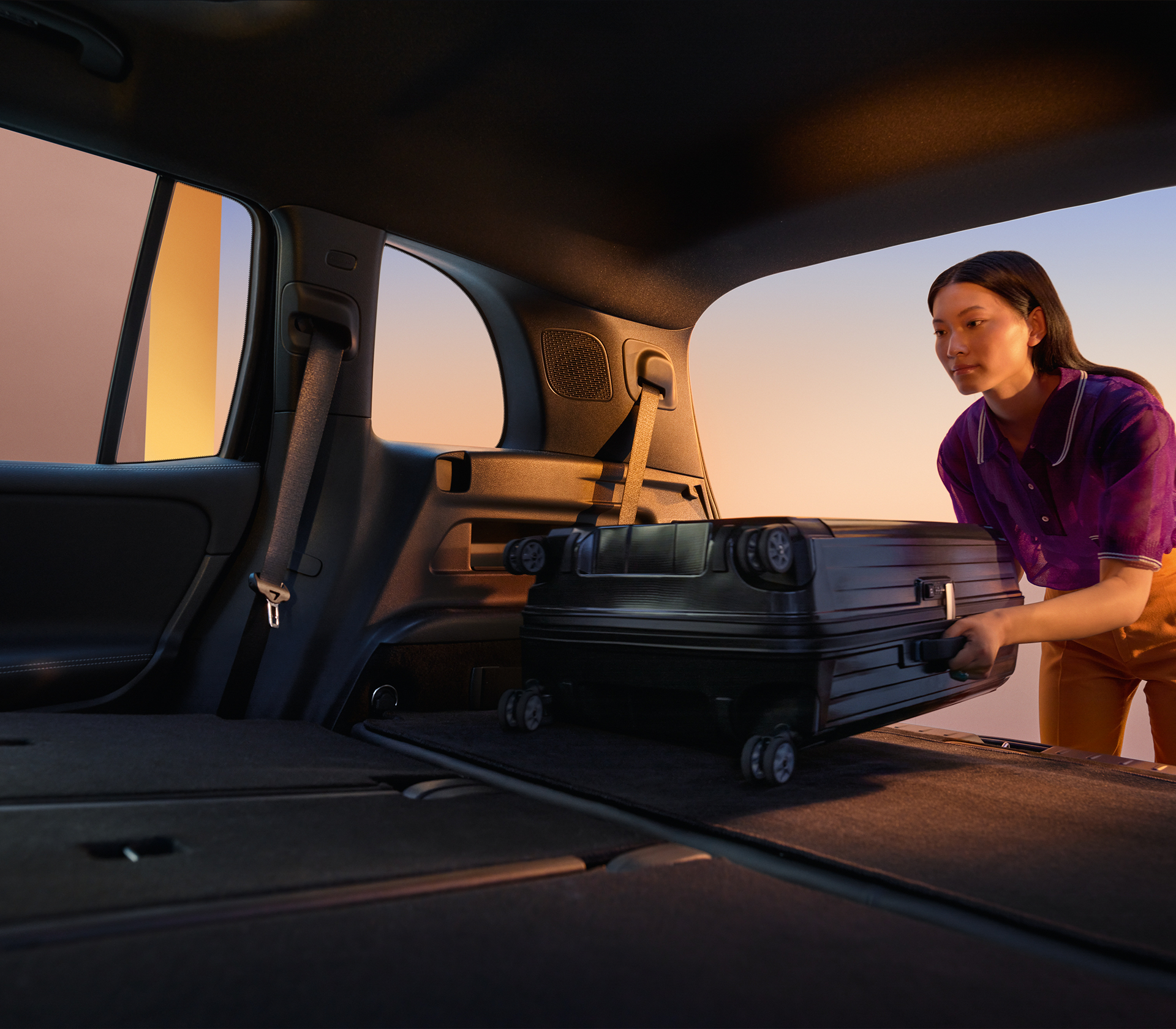 Mercedes-Benz EQB Frau tut Koffer in einen geräumigen Kofferraum