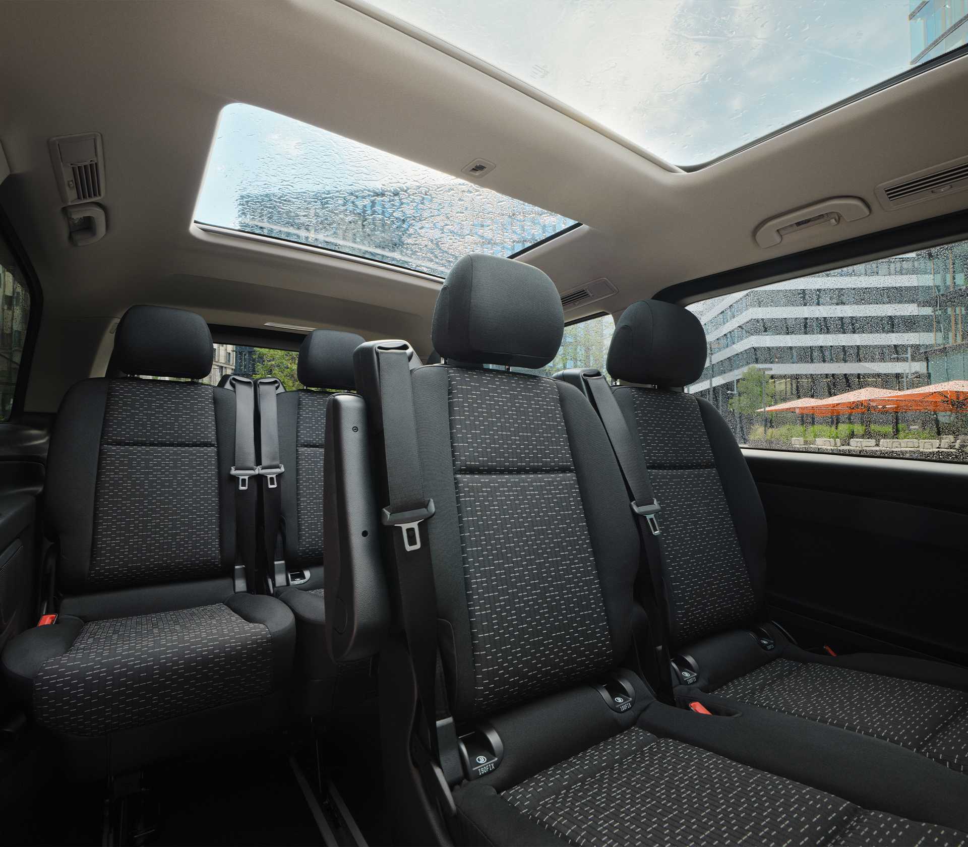 „Innenraum eines Mercedes-Benz Vito mit drei Sitzreihen und großem Panoramaglasdach, aufgenommen bei Regen.“