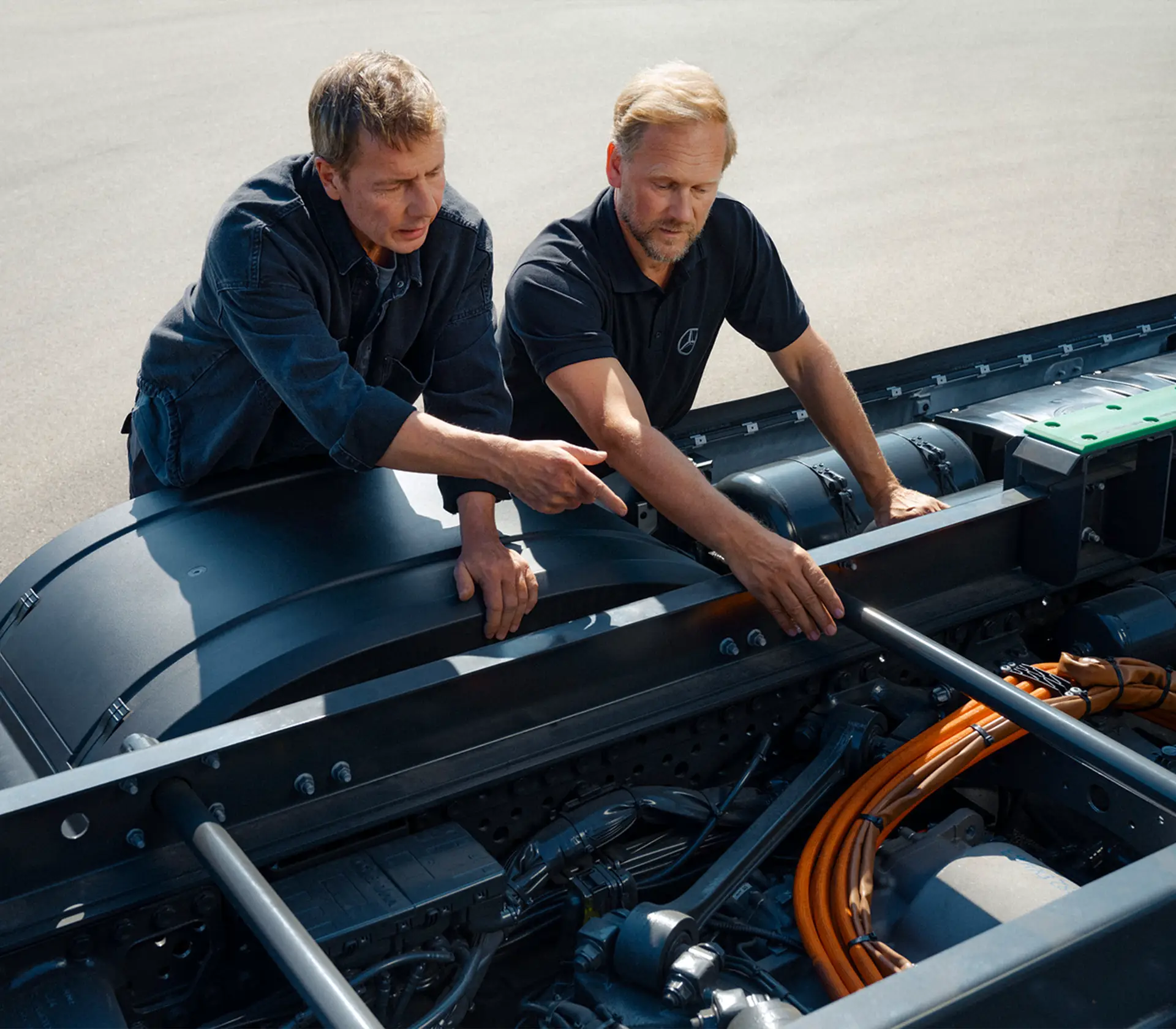 Person erklärt einer anderen Person die Hochvoltanlage eines eActros