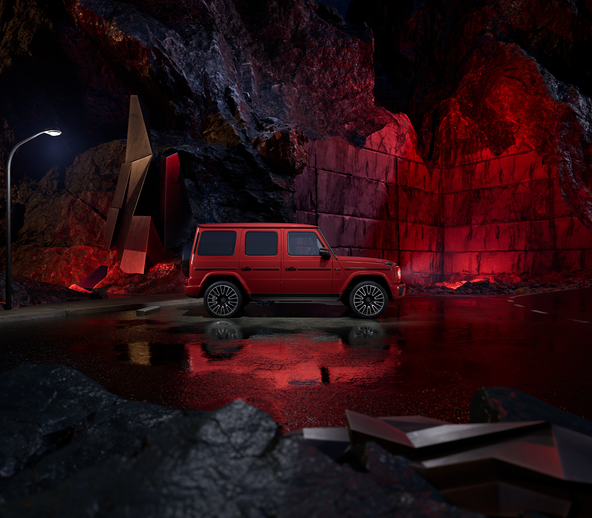 Seitliche Ansicht einer Mercedes-Benz G-Klasse in auffälligem Rot, inszeniert vor dramatischer Felskulisse mit roter Beleuchtung und nasser Fahrbahn.