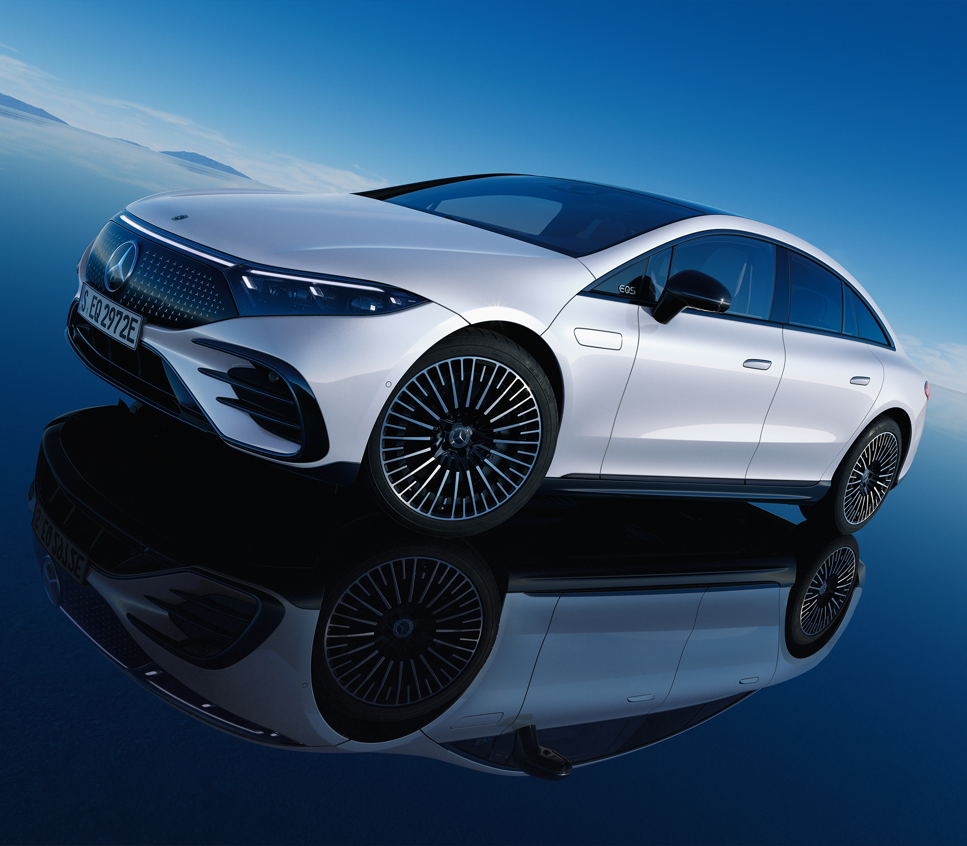 Mercedes-Benz EQS-Limousine in weiß auf Blauem Hintergrund.