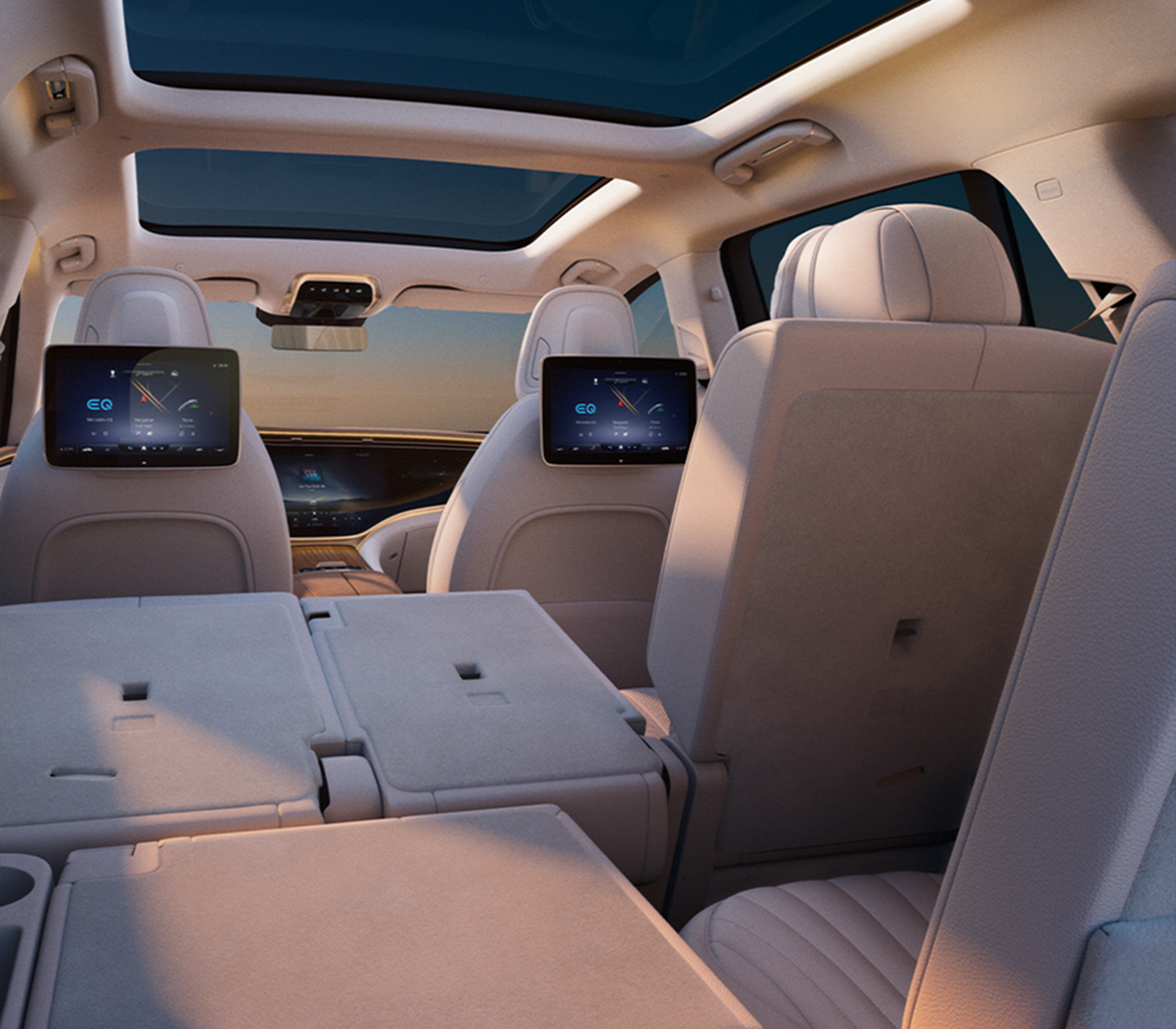 Mercedes-Benz EQS SUV Sicht aus dem Kofferraum auf umgeklappte weiße Sitze und die Bildschirme auf den Vordersitzen