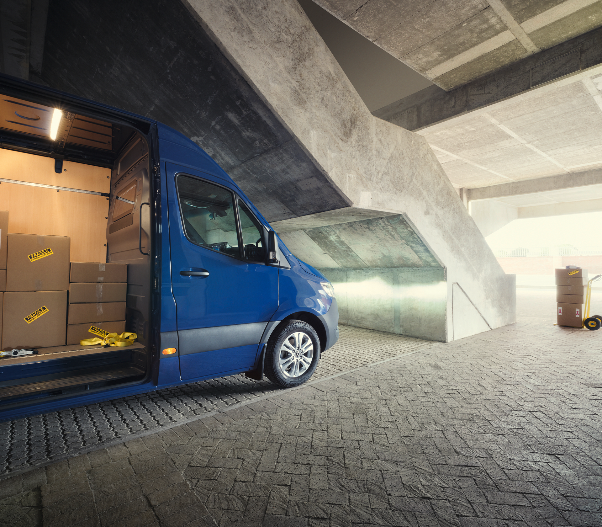 Mercedes-Benz Sprinter in blau mit offener Seitentür und Paketen im iInneren