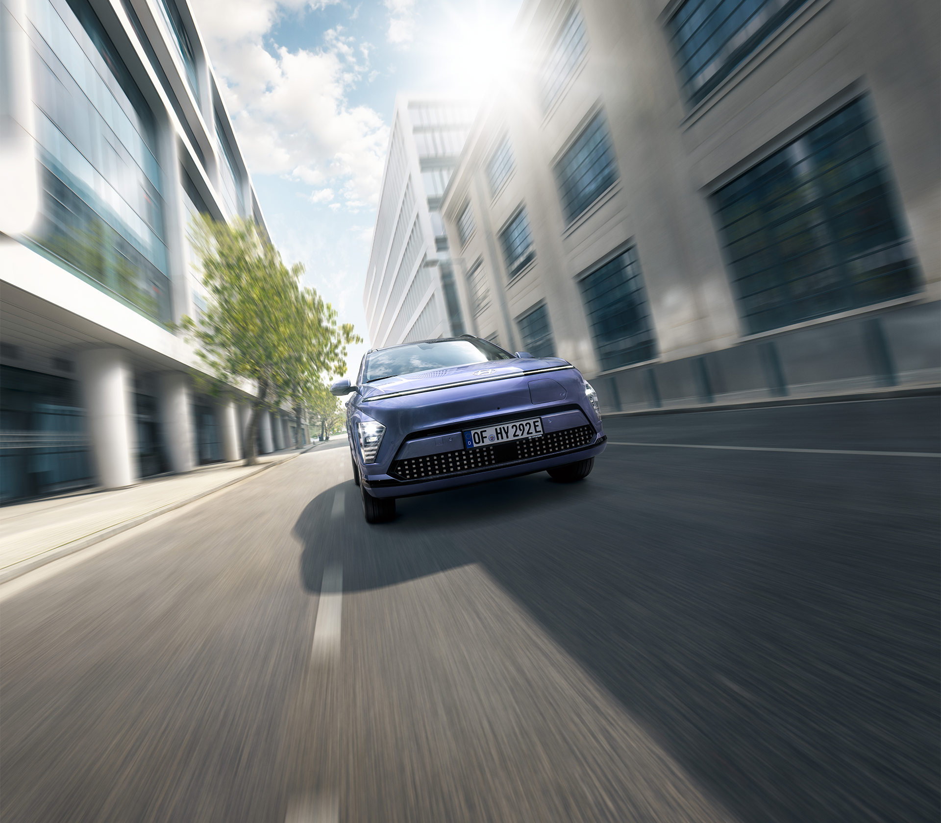 Hyundai SUV Kona elektro fährt auf der Straße mir Gebäuden drum herum