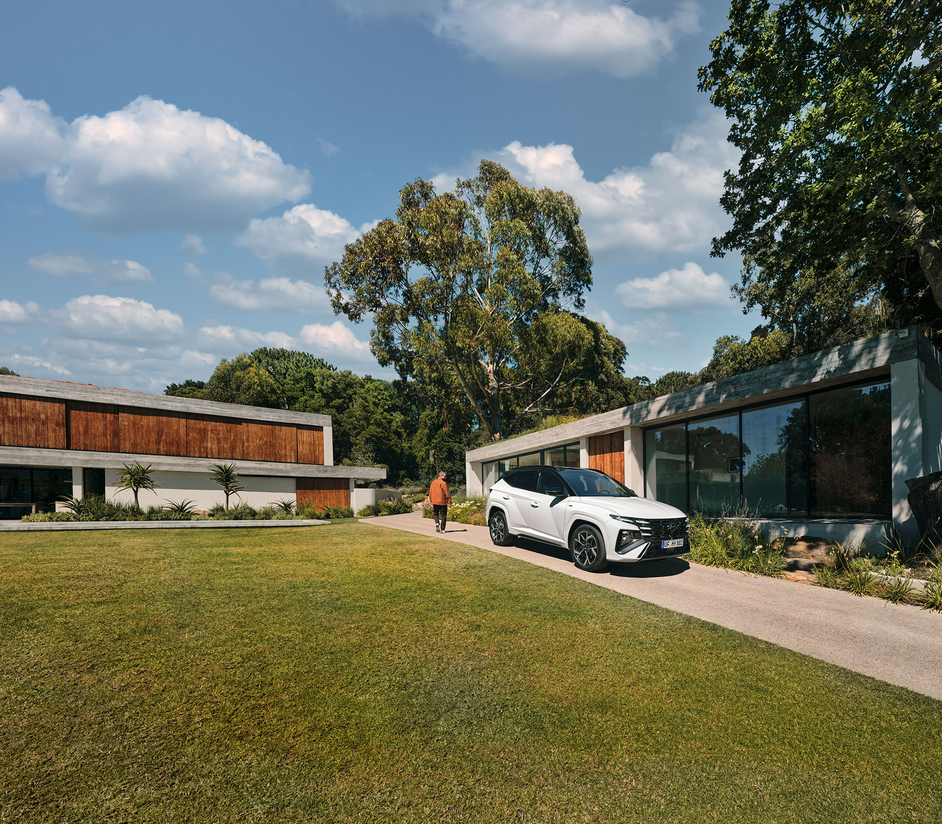 Hyundai TUCSON schräg von der Seite Auto in weiß mit einem modernen Gebäude im Hintergrund