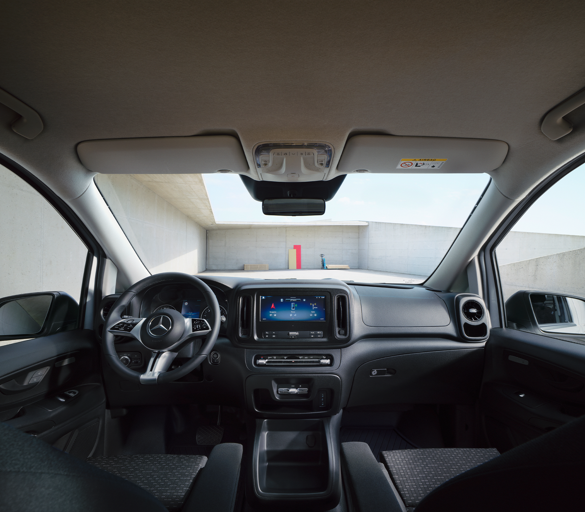 „Fahreransicht im Mercedes-Benz Vito mit moderner Instrumententafel und zentralem Infotainmentdisplay.“