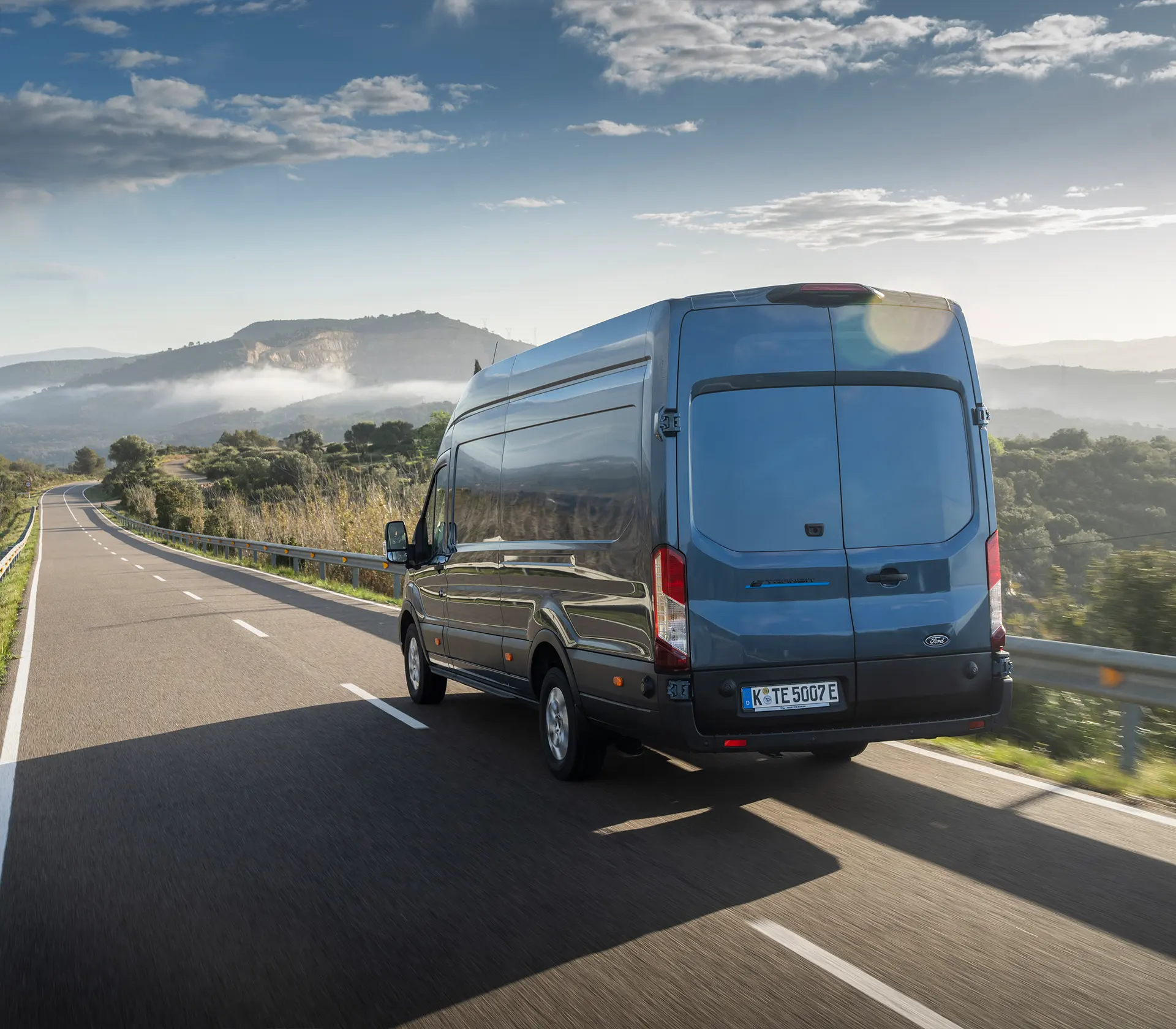 Heckansicht auf einen blauen E-Transit auf der Autobahn