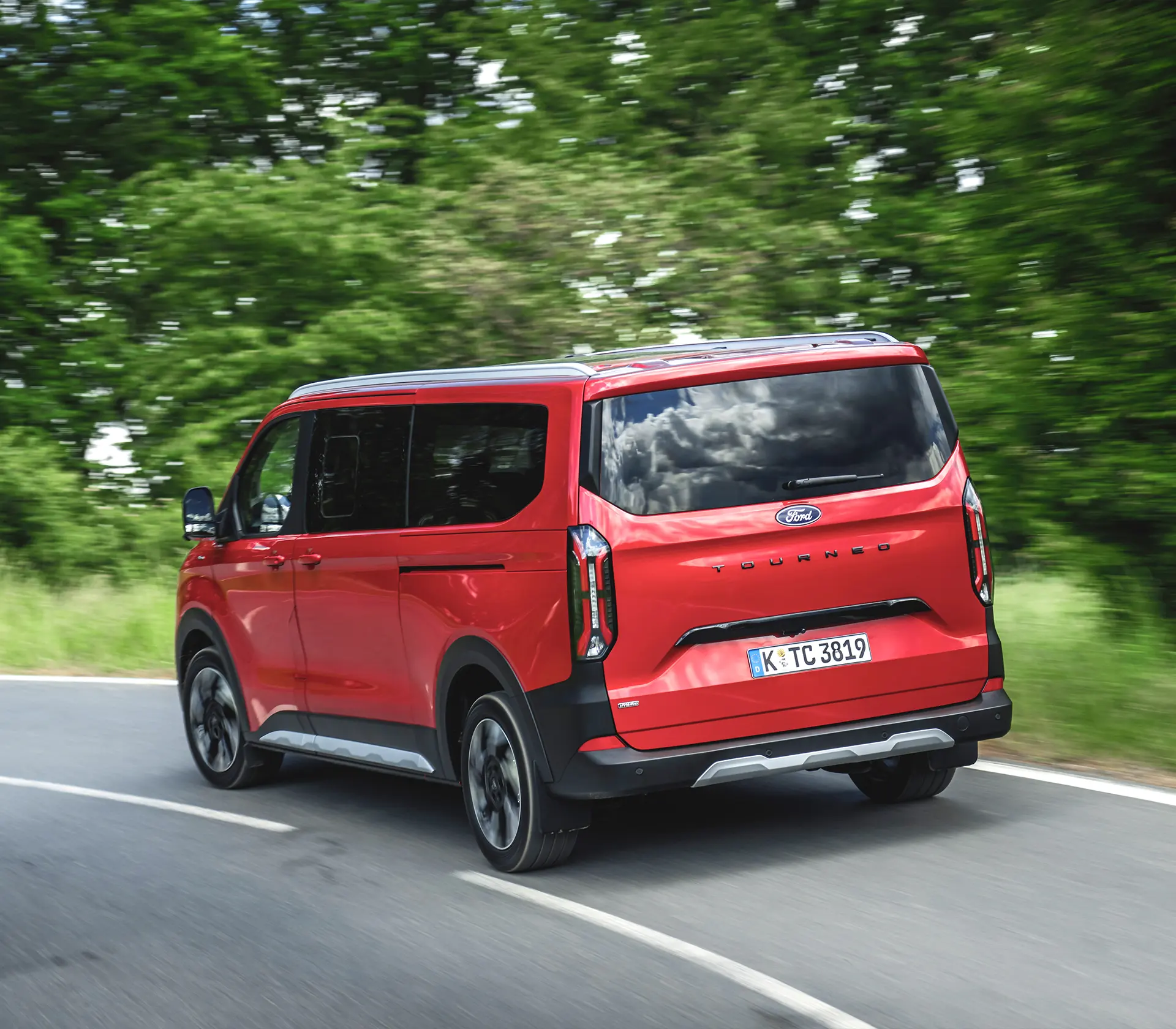 roter Ford Tourneo-Custom fährt auf der Landstraße - Heckansicht
