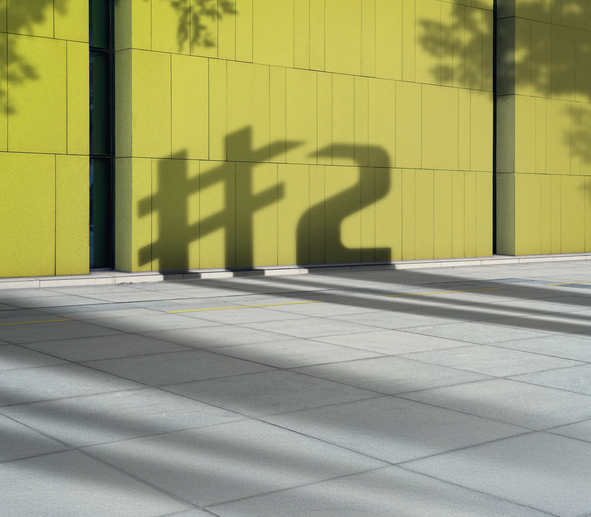 der Schatten von dem smart #2 Logo vor einer Grünen Wand
